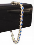 JOIA, uma (1) pulseira, confeccionada em PRATA DE LEI, contrastada 925, ricamente incrustada por pedrarias na tonalidade azul, possivelmente água-marinha, e pedrarias translucidas, fecho tipo lobster, medindo 24,5cm de comprimento e peso total bruto 11g.