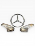 COLECIONISMO, três (3) peças, sendo: A) um (1) emblema circular em material plástico com estrela de três pontas da marca Mercedes-Benz, apresenta quebra nas travas traseiras e falhas na prateação, medindo 26cm e B) um (1) par de lanternas automotivas de carroceria, apresentando sinais de uso, oxidações, desgastes e marcas do tempo, vendida no estado, medindo 13x21x7cm.