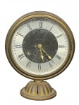 RELÓGIO DELUXE (marca de uso comercial encontrada em relógios decorativos do século XX, voltada à produção de peças utilitárias e ornamentais de apresentação clássica), um (1) relógio despertador de mesa em metal dourado, mostrador circular com algarismos romanos, centro com decoração floral em relevo/gravada, ponteiros trabalhados e base torneada. Peça apresentando sinais do tempo, oxidação, desgastes no acabamento e rachadura/fenda aparente na base. Medidas 9x7cm Sem garantia de funcionamento.