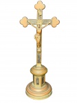 ARTE SACRA, um (1) crucifixo de mesa, confeccionado em metal espessurado a prata com falhas na prateação, laterais recortadas, apoiada sobre base circular escalonada, necessita banho, medindo 33x13cm.