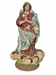 ARTE SACRA, uma (1) imaginária representando Nossa Senhora da Conceição confeccionada em estuque patinado com pintura em policromia, apresenta desgastes na patina, apoiada sobre base adaptada em vidro pintado, vendida no estado, possui falhas, percas e restauros na peça, medindo 26cm de altura.