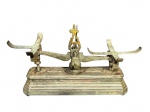 DIVERSOS, uma (1) antiga balança em ferro fundido, marca Force, capacidade para 1 kg, com base retangular escalonada e braços superiores para suporte dos pratos. Peça apresentando sinais do tempo, oxidação e marcas de uso, ausência dos pratos, medindo 16x28,5x11,5cm.