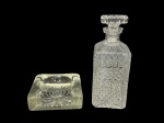 VIDROS, lote com duas (2) peças confeccionadas em vidro translucido, sendo: A) 1 garrafa para whisky, moldagem em BICO DE JACA e caneluras, medindo 24cm de altura e B) 1 cinzeiro quadrado, corpo liso e fundo estrelado, medindo 4,5x14,5x14,5cm.