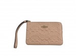 ACESSÓRIO FEMININO, uma (1) bolsa de pulso COACH (marca norte-americana fundada em 1941, em Nova York, reconhecida por seus artigos de couro e acessórios de luxo), em couro texturizado na cor bege/nude, com padrão monograma em relevo, ferragens douradas, fecho por zíper e alça lateral de pulso, medindo 10,5x16cm.