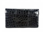 ACESSÓRIO FEMININO, uma (1) bolsa clutch da marca NANCY GONZALEZ COLOMBIA (designer colombiana reconhecida internacionalmente por bolsas de luxo confeccionadas em peles exóticas e acabamento artesanal), em couro legítimo de crocodilo na cor preta, formato retangular, com aba frontal e padronagem natural característica da pele, apresentando acabamento brilhante, interior em veludo verde com 1 bolso, apresenta sinais de uso, medindo 15x24,5cm.