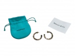 BIJUTERIA FINA, um (1) par de brincos de argola da marca TIFFANY & CO. (tradicional maison norte-americana fundada em Nova York no século XIX, reconhecida mundialmente por sua alta joalheria, pratarias e objetos de luxo), em metal dourado, acompanhados de caixa, bolsa e cartão da marca. Peças de desenho clássico, apresentando leves sinais de uso, medindo 3,2cm.