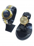 RELÓGIOS, dois (2) relógios de pulso, sendo: A) relógio da marca Movado (tradicional marca suíça fundada em 1881, reconhecida internacionalmente pelo desenho moderno e sofisticado de seus relógios, notadamente por modelos de estética minimalista), com movimento quartz, caixa circular em aço bicolor, mostrador preto com assinatura visual de ponto único, pulseira em aço bicolor, fundo com numeração 81.E3.868 e 282790, apresentando sinais de uso, não testado e sem garantia de funcionamento, medindo 3,5cm e B) relógio da marca Cyma (tradicional marca suíça de relojoaria, fundada em 1862, reconhecida pela produção de relógios clássicos de boa qualidade e longa tradição no mercado), modelo CYMAFLEX, com movimento mecânico, caixa circular em metal dourado, mostrador dourado, pulseira em couro preto, fundo liso, apresentando sinais do tempo e do uso, não testado e sem garantia de funcionamento, caixa medindo 2,5cm.