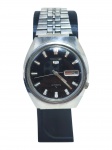 RELÓGIO, um (1) relógio de pulso da marca Seiko 5 (tradicional marca japonesa fundada em 1881, reconhecida mundialmente pela qualidade de seus relógios e pela relevância histórica na relojoaria, inclusive como uma das pioneiras na popularização dos mecanismos automáticos e quartz), com movimento automático, caixa circular em aço, mostrador preto com calendário duplo de dia e data, pulseira em aço, fundo c/ numeração 2205-0760-R, apresentando de uso, visor em acrílico em excelente estado, funcionando, sem garantias futuras, caixa medindo 35mm.