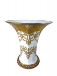 ROSENTHAL (Foi fundada em 1879 por Philipp Rosenthal, na Baviera, Alemanha), um (1) vaso cônico confeccionado em porcelana alemã na tonalidade branca, ricamente decorada por guirlanda de arabescos e elementos vegetalistas em vasta douração, base moldada por flores e frutos relevados, também, em vasta douração, possuindo restauro na base, falhas no ouro, medindo 28x35cm.