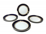 PORCELANA STEATITA, oito (8) pratos rasos confeccionados em porcelana nacional na tonalidade branca, decorada por espessa faixa na tonalidade azul cobalto e faixa em ouro com elementos vegetalistas, 1 bicado, medindo 24,5cm.