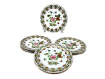 PORCELANA ORIENTAL, nove (9) pratos rasos confeccionados em porcelana na tonalidade branca, decorada por flores, folhagens e frutos em rica policromia com filetes e realces em ouro, medindo 23,5cm de diâmetro.