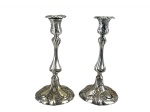 METAL PRATEADO - Par de castiçais, de elegante feitio alongado, com bobeches recortados, fustes torneados e bases movimentadas em desenho lobulado, ricamente ornamentadas em relevo com motivos vegetalistas , medida : 28 x 13,5 cm