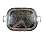 METAL PRATEADO, uma (1) grande bandeja retangular confeccionada em metal espessurado a prata, fundo com rico cinzelado de elementos florais e vegetalistas, galeria em gomos, alças vazadas e banho em bom estado com leves sinais de uso, medindo 67x42,5cm.