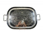 METAL PRATEADO, uma (1) grande bandeja retangular confeccionada em metal espessurado a prata, fundo com rico cinzelado de elementos florais e vegetalistas, galeria em gomos, alças vazadas e banho em bom estado com leves sinais de uso, medindo 67x42,5cm.
