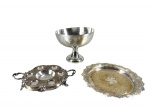 METAL PRATEADO - Três (3) peças em metal espessurado à prata, sendo: A) uma (1) taça de formato semiesférico, elevada sobre pé circular; med : 16,5 x 20 cm , possui mossa ,  B) um (1) porta licoreiro de formato circular, com cavidade central, seis encaixes e alças laterais; med : 3 x 24 x 20  C) uma (1) bandeja circular da manufatura Meridional , com centro gravado e borda rendilhada recortada , medida : 25 cm , desgastes no banho . 