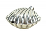 METAL PRATEADO / EBERLE - Uma (1) manteigueira ou porta-joias em metal prateado, de formato concheado, com tampa articulada e interior com recipiente em vidro azul , não acompanha espátula . Medida : 6 x 13 x 13 cm