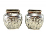 METAL PRATEADO - Dois (2) pequenos cachepôs em metal prateado, da famosa loja "Le lis Blanc" de formato quadrangular, com corpo bojudo, bordas retangulares, decoração em relevo com motivos florais e folhagens estilizadas. Medidas : 10 x 6,5 x 5,5 cm
