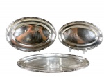 METAL PRATEADO, três (3) travessas confeccionadas em metal espessurado a prata da manufatura WOLFF, borda cinzelada em caneluras, fitas e ROSINHAS, sendo: A) 2 ovais, medindo 37x25cm e 42x30,5cm e B) 1 para peixes, medindo 49,5x20,5cm. Leves sinais de uso.