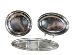 METAL PRATEADO, três (3) travessas confeccionadas em metal espessurado a prata com borda cinzelada em perolados, sendo: A) 1 redonda, medindo 33cm e B) 1 oval, medindo 42x30cm e C) 1 para peixes, medindo 50x21cm, apresentam sinais de uso.