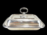 CHRISTOFLE (É uma renomada marca francesa fundada em 1830 por Charles Christofle), uma (1) legumeira com tampa reversível para travessa confeccionada em metal francês espessurado a prata com cinzelado de caneluras, medindo 15,5x28x21cm. Leves falhas na prateação.