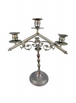 ARTE SACRA, um (1) candelabro para três velas confeccionada em bronze, corpo torneado, base circular escalonada, cinzelado por arabescos em vazados e figura angelical, laterais finalizadas em bilros, vestígios de banho de prata, medindo 31cm de altura. Mossa na bobeche.