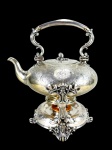 METAL INGLÊS, um (1) samovar confeccionado em metal espessurado a prata, ricamente cinzelada por elementos florais e vegetalistas, alça central articulável em recortes com isoladores em marfim (1 com quebra), hastes laterais no feitio de arabescos e pés no feitio de folhagens e pega da tampa no feitio de fruto, apresenta discretas mossas e pequenas falhas na prateação, medindo 36x29,5x23cm.