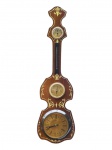 RELÓGIO JUNKER (marca alemã ligada à tradição relojoeira e de instrumentos domésticos de medição, conhecida por produzir relógios e conjuntos murais de uso decorativo e funcional no século XX), um (1) conjunto mural em madeira, com aplicações decorativas, composto por relógio com mostrador de numeração romana, termômetro, barômetro e higrômetro, maquina do relógio a pilha com ausência do visor frontal, não testado e sem garantia de funcionamento, medindo 85x24cm.