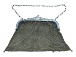 ACESSÓRIO FEMININO, uma (1) bolsa de festa confeccionada em malha de metal espessurado a prata, borda cinzelada por elementos vegetalistas, apresenta desgastes, necessita reparo, vendida no estado da foto, medindo 16x16cm.