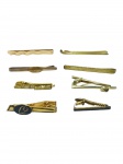 METAL DOURADO, oito (8) prendedores de gravata confeccionados em metal dourado de modelos, tamanhos e decorações distintas, maior medindo 7cm e menor 4,5cm.