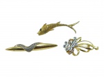BIJUTERIAS, lote com três (3) broches, confeccionados em metal dourado de modelos distintos, sendo: A) um (1) broche em formato de peixe, com textura em relevo e aplicação de olho em pedra escura, leves falhas na douração, medindo 8 cm; B) um (1) broche de desenho abstrato alongado, com aplicação de pequenas pedras translúcidas, medindo 8cm e C) um (1) broche floral estilizado, com haste sinuosa e aplicações de pedras translúcidas, medindo 6x3,5cm. Peças apresentando sinais do tempo e de uso.