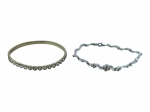 BIJUTERIAS, lote com duas (2) peças, sendo: A) 1 bracelete, confeccionado em metal dourado, decorado por corações incrustados por cristais translúcidos, medindo 6,5x6cm e B) 1 pulseira, confeccionada em metal espessurado a prata, elos torcidos, com incrustação de pedra translucida, medindo 20cm de comprimento.