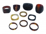BIJUTERIAS, lote com dez (10) anéis de modelos, tamanhos, decorações e materiais distintos, sendo: A) 2 em ônix ou similar, B) 3 em casco de tartaruga, C) 4 em quartzo de diferentes tonalidades e D) 1 em chifre polido, aros 24, 14, 20, 22, 20, 14, 21 e 17.
