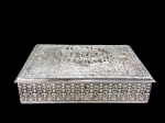 METAL PRATEADO - uma (1) grande caixa retangular em metal espessurado à prata , ricamente cinzelada em relevo com composição floral , parte central com cena campestre em reserva , laterais ornadas com padrão repetitivo de inspiração neogótica , não acompanha chave , ausência dos pés e possui furos para caixa musical , med : 7 x 24 x 31 cm