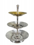 METAL PRATEADO - (1) Pequena fruteira confeccionada em metal espessurado à prata , com três estágios , com hastes centrais e pratos circulares escalonados, medida : 21 x 15 cm , necessita de banho .