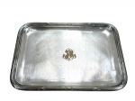 CHRISTOFLE (É uma renomada marca francesa fundada em 1830 por Charles Christofle), uma (1) bandeja retangular, confeccionada em metal francês espessurado a prata, borda cinzelada em caneluras e fitas cruzadas e monograma PA ao centro, falhas na prateação, medindo 22x17cm.