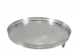 METAL PRATEADO, uma (1) bandeja circular, confeccionada em metal espessurado a prata, fundo cinzelado por elementos vegetalistas, galeria e base em vazados e borda em ondulações, medindo 25,5cm.