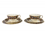 GRINDLEY ENGLAND (fábrica W. H. Grindley & Co. Ltd., de Tunstall, Staffordshire, Inglaterra, ativa de 1880 até o fim do séc. XX), linha COLERIDGE, par (2) de trios para chá, sendo: A) 2 xícaras para chá com seus respectivos pires, medindo 6x11,5x9cm e B) 2 pratos para biscoito, medindo 17,5cm, confeccionados em faiança inglesa na tonalidade creme mcom pintura de guirlanda floral em policromia sobre fundo azul e realces dourados, apresenta falhas na douração, 1 pires com fio de cabelo e leves marcas do tempo.