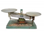 DIVERSOS, uma (1) balança manual de dois pratos da marca AROSA, fabricação nacional, em metal pintado, com escala frontal graduada. Peça apresentando oxidação, desgastes e sinais do tempo, medindo 10x24x9,5cm.