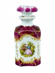 PORCELANA, um (1) perfumeiro confeccionado em pocelana na tonalidade branca, esmaltado na tonalidade roxa, adornos vegetalistas em ouro e reserva de cena galante em policromia, apresenta falhas na pintura, medindo 12cm de altura.