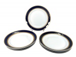 PORCELANA STEATITA, sete (7) pratos rasos confeccionados em porcelana nacional na tonalidade branca, decorada por espessa faixa na tonalidade azul cobalto e faixa em ouro com elementos vegetalistas, medindo 24,5cm.