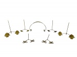 METAL DOURADO, sete (7) peças confeccionadas em metal dourado, sendo: A) 2 suportes para pratos, hastes cilíndricas com apliques de concheados em recortes, medindo 20x21cm, B) 2 suportes para pratos, hastes cilíndricas com apliques de folhagens, medindo 19x16cm, C) 2 suportes para pratos com hastes cilíndricas e apliques de laçarotes, medindo 9x13cm e D) 1 alça para prato/bandeja com apliques florões em vazados, medindo 17x29cm.