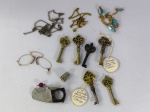 Lote com chaves antigas e correntes douradas com pedras brilhantes, óculos, dedal prateado