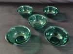 Conjunto com cinco tigelas pequenas de vidro tipo pyrex com um tom azulado.
