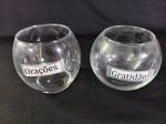 Dois vasos redondos de vidro, utilizados como pequenos aquários ou para decoração.  Com adesivos escrito.