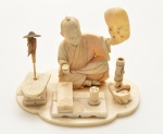 Japão. Meiji. Séc. XIX - Grupo escultórico da manufatura japonesa, esculpido em marfim, representando artesão de máscaras. 7 x 11 cm.