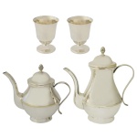 Lote constando de 4 peças em metal prateado, sendo duas da manufatura nacional Wolff. A) Par de taças (10 x 7 cm). B) Conjunto de 2 bules sendo: 1 bule p/ café (22 x 21 x 12 cm) e um bule p/ chá (17 x 20 x 11 cm).