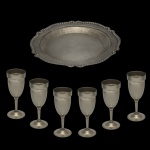Lote constando de 7 peças, sendo: 1 bandeja em metal prateado boliviano (29 cm) e conjunto de 6 taças em Pewter (16 cm).