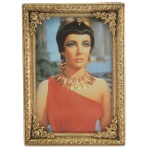 Porta retrato de formato retangular, esculpido em madeira entalhada e dourada. 11 x 7 cm (MI). 14 x 10 cm (ME).