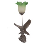 Luminária de mesa montada com escultura em bronze representando águia de asas abertas, pousada em base com rochedos. Montagem com haste tubular reta encimada por tulipa em cristal rematada por borda ondulada e revirada de cor verde. 62 cm (MT). 33 x 21 cm. 15 x 18 cm (cúpula).