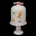 Modelo Gingerbread - Porta panetone em cerâmica artesanal da manufatura nacional Luiz Salvador, Itaipava. Apresenta design temático de Natal com decoração inspirada nos biscoitos de gengibre. Pega da tampa na forma de bala. Peça decorativa e funcional para servir e armazenar panetones. Marca da manufatura no verso. Peças sem uso. 33 x 18 cm (MT).